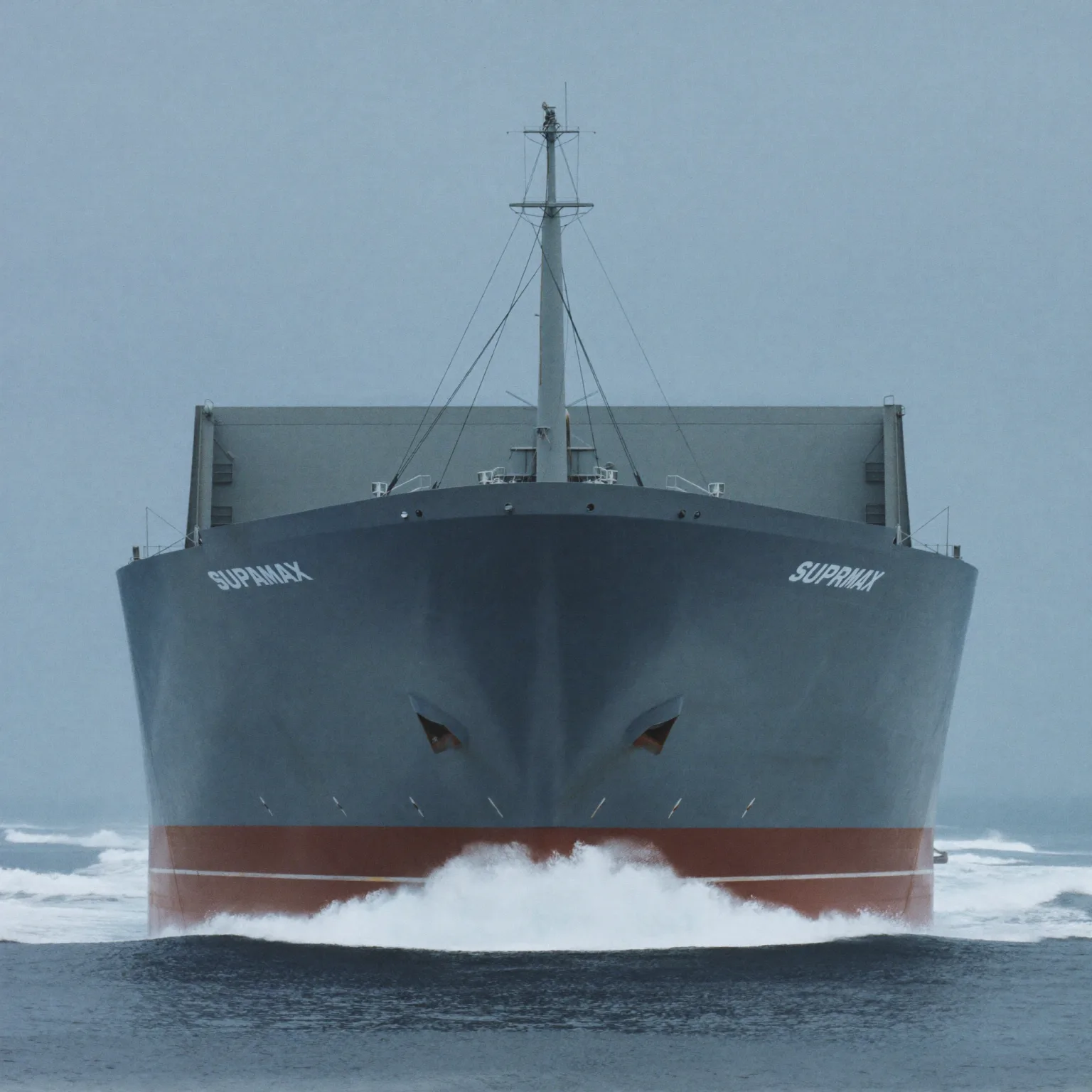 The same bulk carrier under way at sea, loaded, bow wave